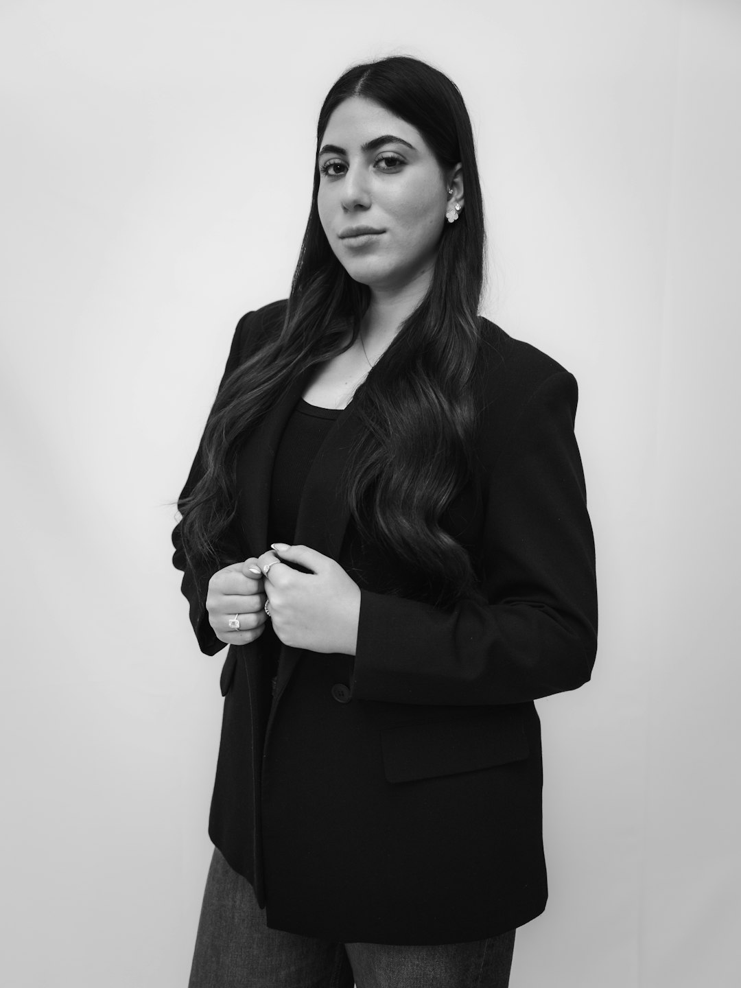 A woman in a black blazer and dark top.